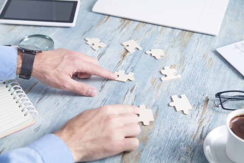 businessman-solving-puzzle-office-desk