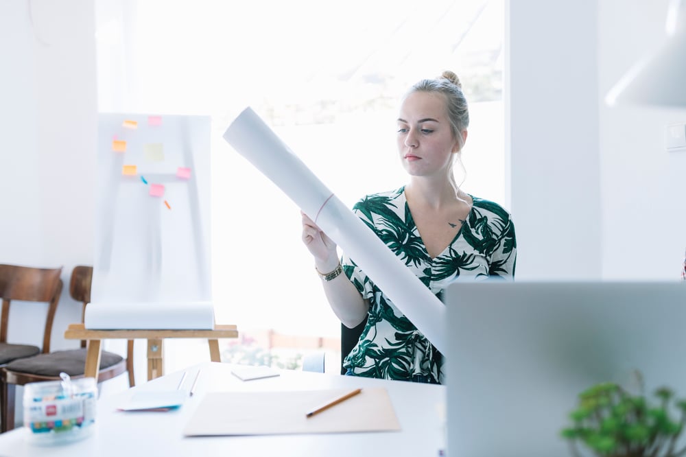 businesswoman-putting-rubber-band-rolling-chart-office