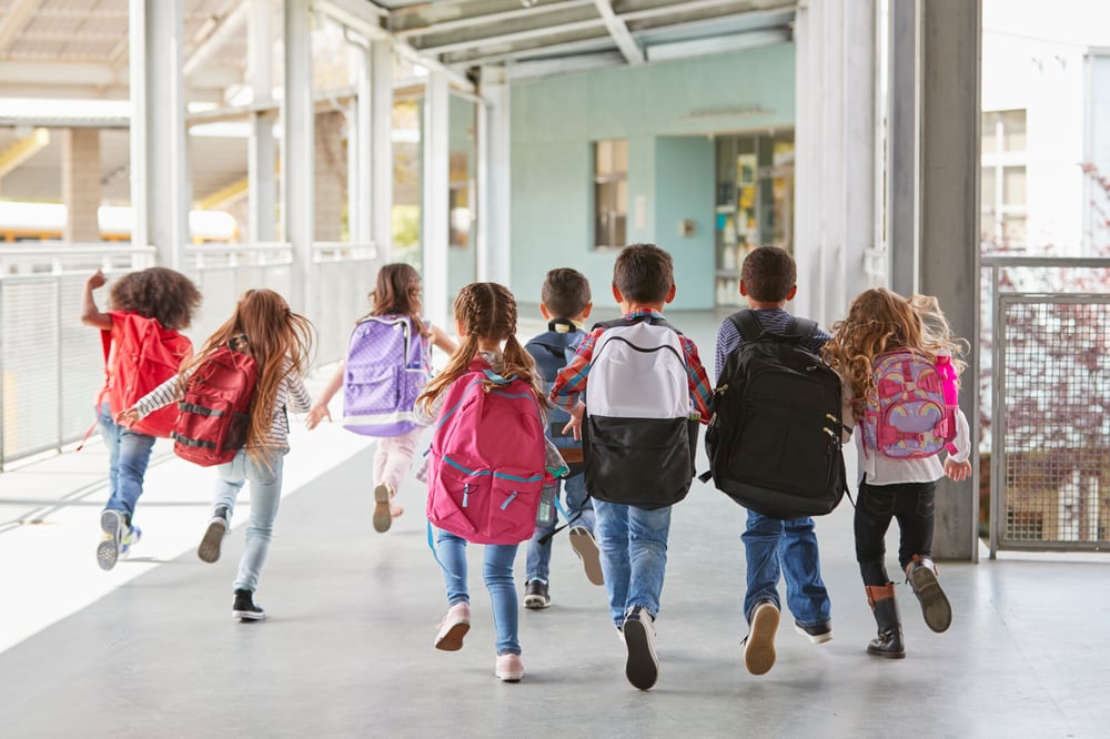 elementary-school-kids-run-from-camera-corridor-close-up