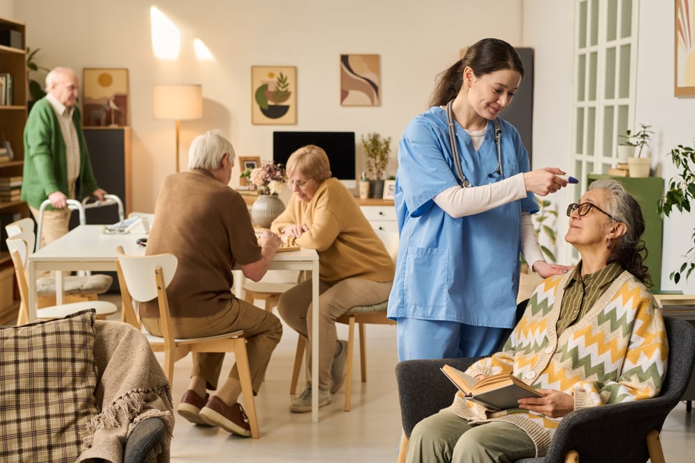 female-caregiver-assisting-senior-woman-nursing-home-lounge