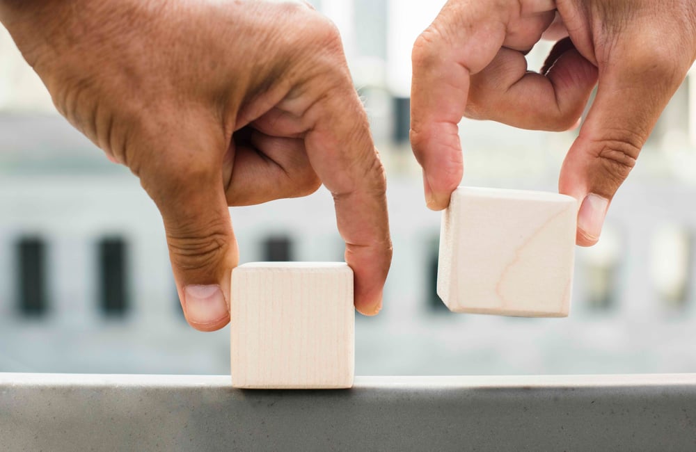 hands-placing-cubes-surface