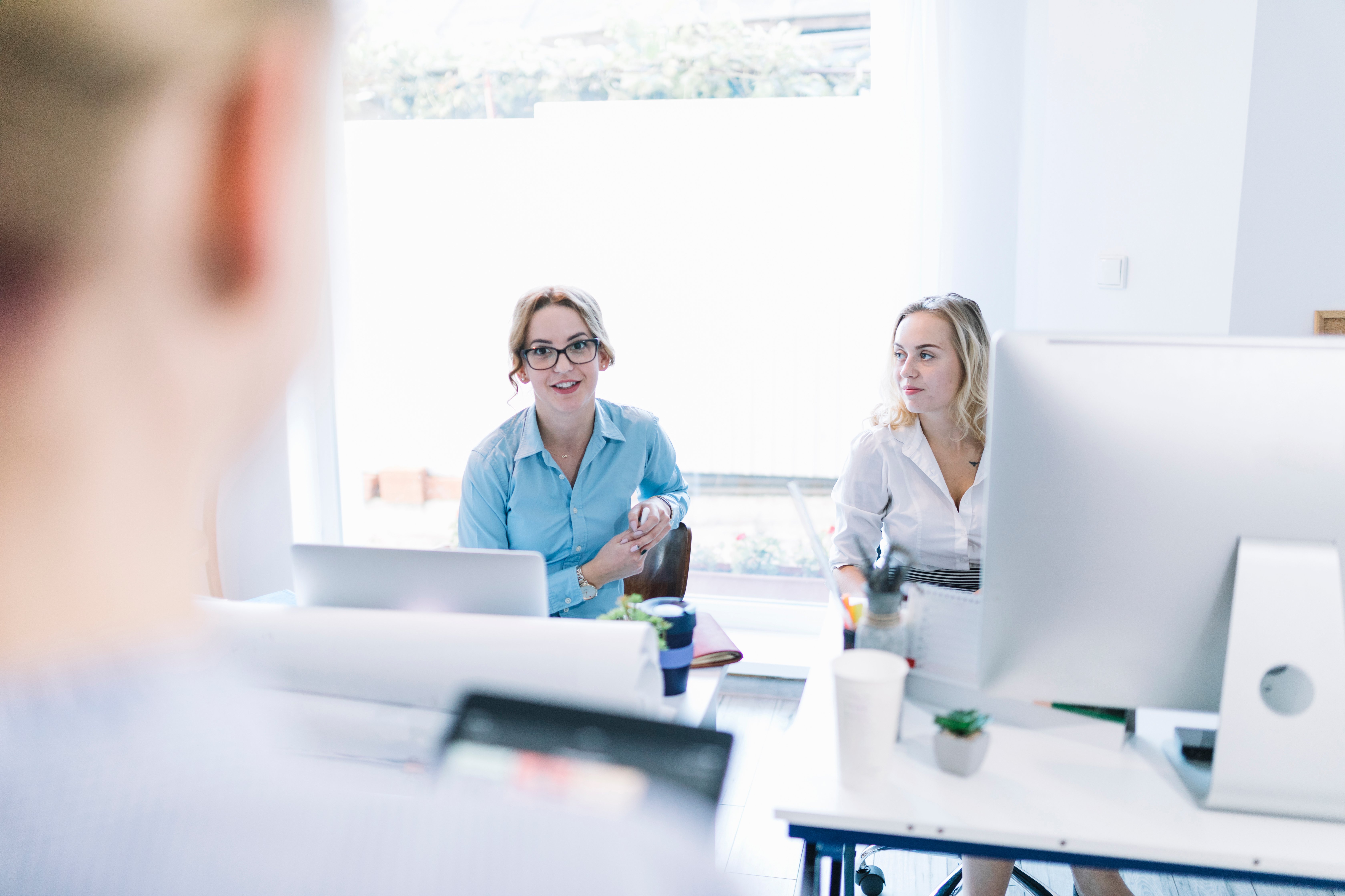 two-smiling-businesswomen-sitting-in-a-meeting-in-an-office