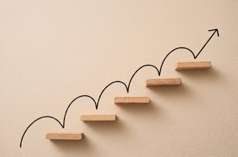 upward-trending-arrow-with-wooden-steps-wall